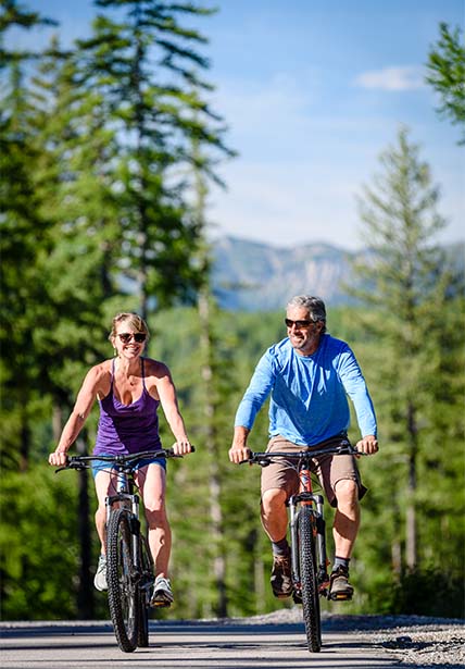 tow adults riding mountain bikes