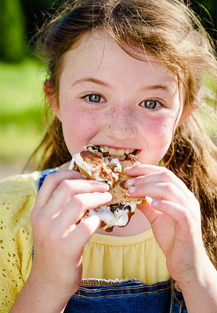 girl eats a s'more