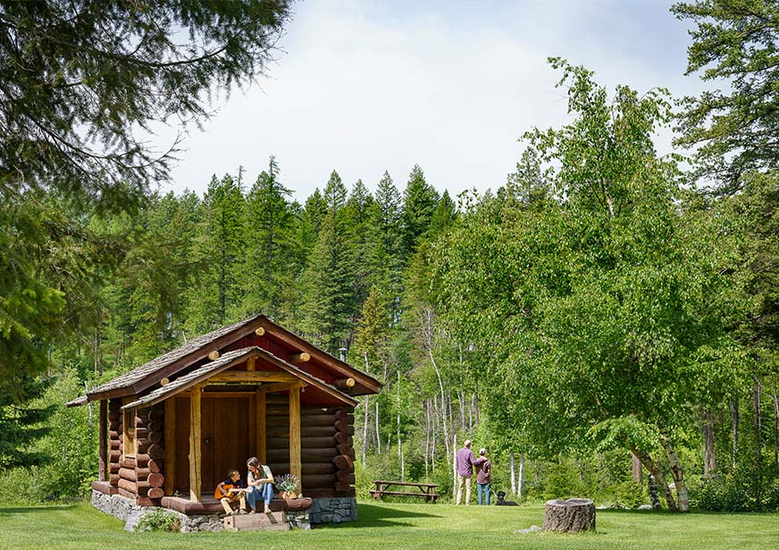 family recreating near a log cabin